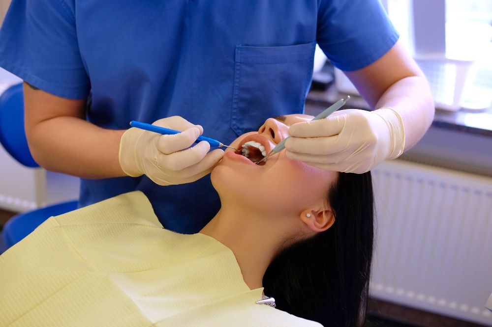 dentist-hands-working young woman patient with dental tools